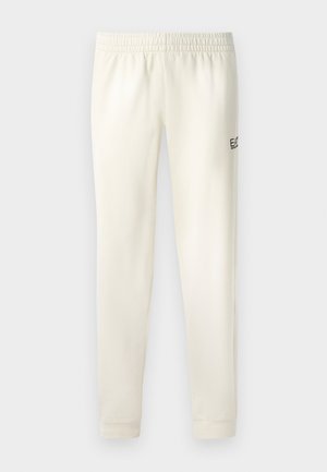 White sweatpants with an elastic waistband, cuffed ankles, and a small black logo on the left side. Smooth cotton material.