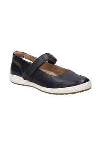 Zapato Mary Jane de cuero negro con diseño perforado, correa ajustable y suela blanca. Perfil plano con punta redondeada y interior acolchado.