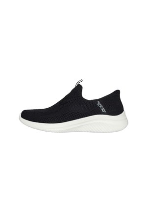 Zapatilla negra de malla sin cordones con punta redonda, suela de goma blanca y una lengüeta en el talón para facilitar su uso.