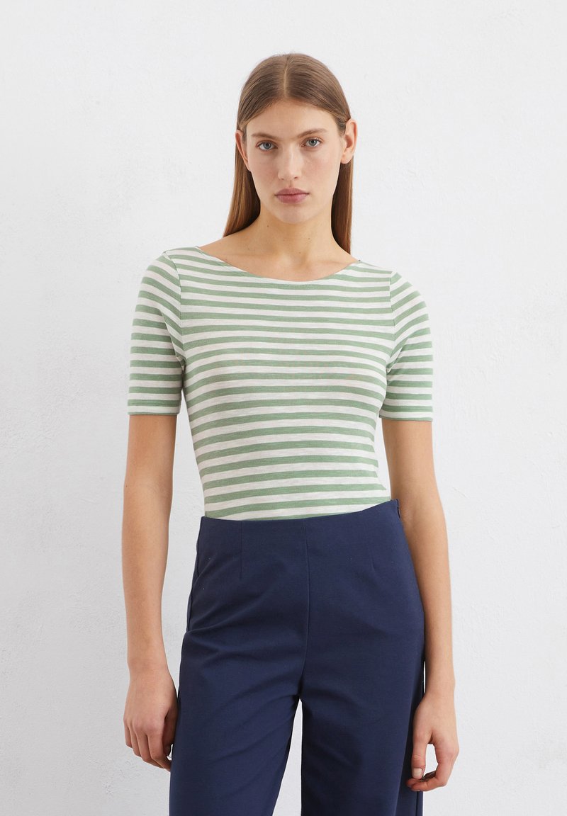 Grün-weiß gestreiftes Kurzarm-T-Shirt mit weitem Ausschnitt, kombiniert mit navyblauen hoch taillierten Hosen, die eine figurbetonte Silhouette bieten.