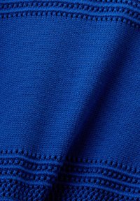 Blaues Textil mit einem strukturierten Strick und offenen Nähakzenten. Glatte Textur mit einer lebhaften einheitlichen Farbe und durchgängigem Muster.