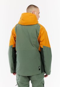Waterdichte jacket met een groene body en een oranje capuchon. Heeft een relaxte pasvorm, een verstelbare capuchon en een logodetail op de achterkant.