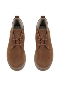 Bottines en daim marron avec un bout rond, semelle en caoutchouc plate et un laçage minimal. Présente un design épuré et simple ainsi qu'une texture douce.