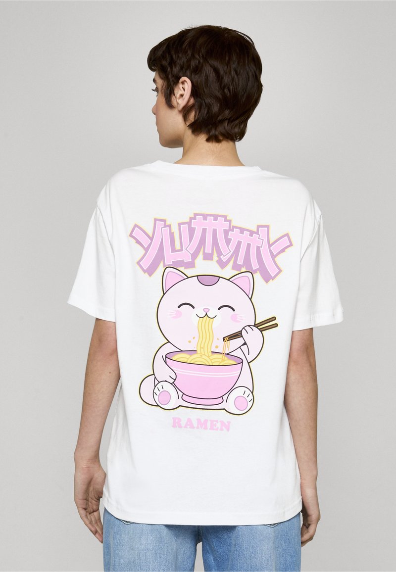 T-shirt blanc à manches courtes avec un chat rose de style cartoon tenant des baguettes et un bol de ramen. Le texte en rose et violet au-dessus du dessin indique "RAMEN".