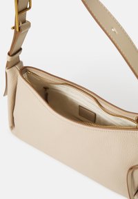 Bežová kožená kabelka s texturovaným povrchem, zlatým zipem a krémovým interiérem. Obsahuje odnímatelný popruh a elegantní, minimalistický design.