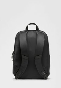 Zwarte rugzak van gladde stof met gewatteerde schouderbanden, een handvat aan de bovenkant en zijzakken met rits. Eenvoudig, rechthoekig ontwerp.