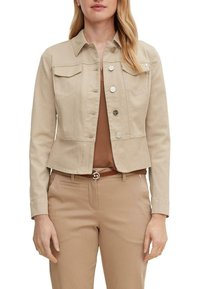 Beige denim jacket with a collared neck, front pockets, and silver button closures. Tailored fit with long sleeves and a cropped design.