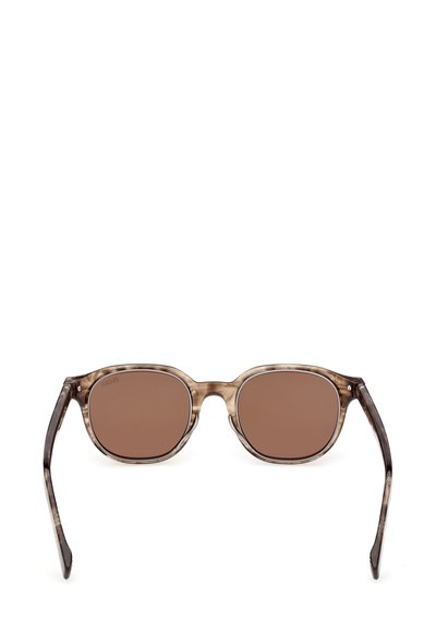 Occhiali da sole con lenti color marrone e montatura traslucida marrone chiaro, forma arrotondata e dettagli marrone scuro sulle aste.