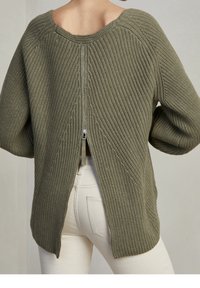 Oljenvihreä neulepusero, jossa on teksturoitu kuvio, pyöreä pääntie ja takana vetoketju. Ominaisuuksiin kuuluvat roikkuneet olkapäät ja halkiokuvio.