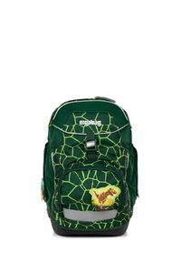Un sac à dos vert avec un motif de carapace de tortue, présentant un design de dinosaure bien en vue sur la poche avant et une bande réfléchissante à la base.