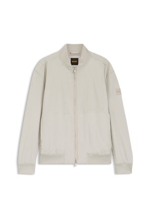 Cazadora tipo bomber beige claro con cremallera, cuello, puños y bajo acanalados, con etiqueta BOSS en el interior y en la manga izquierda.