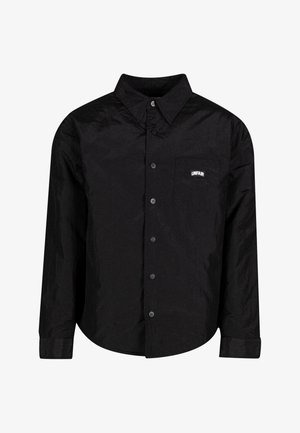 Melna pogca krekls, kas izgatavots no grumbu auduma, ar vienu krūšu kabatu, uz kuras ir "UNFAIR" logo, noapaļotu apakšmalu un garām piedurknēm.