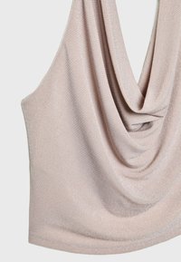 Ljusrosa drapérad topp i ett texturerat tyg med subtila metalltrådar som skapar en mjuk, flödande silhuett.