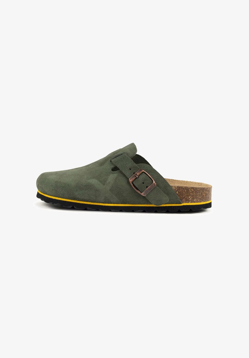 Sabot en daim vert avec un bout arrondi, une boucle métallique ajustable, une semelle intermédiaire en liège et une semelle extérieure en caoutchouc jaune contrasté.