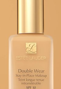 Estée Lauder Double Wear foundation i en glassflaske med gullkork. Etiketten viser produktnavn, SPF 10 og tospråklig tekst i svart.