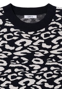 Pull en tricot avec un col rond, présentant une base noire avec un imprimé léopard abstrait blanc. L'étiquette indique "CECIL". Texture de col côtelé.
