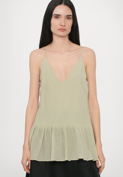 Light green pleated top with a deep V-neck and thin straps, featuring a flared waistline and a textured fabric.