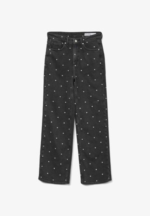 Jean en denim noir avec une coupe loose, ornés de motifs à pois blancs, et design standard à cinq poches avec quincaillerie en métal.