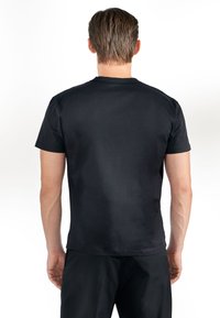 Svart kortärmad T-shirt i mjukt tyg, med klassisk rund halsringning och en figurnära silhuett. Inga synliga mönster eller detaljer.