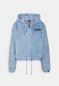 Jasnoniebieska bluza z kapturem z sztucznego futra, krótka, z zamkiem błyskawicznym, ściągaczem w talii i czarną naszywką z logo na piersi. Miękka faktura, długie rękawy.