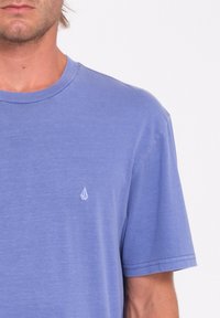Blå kortærmet t-shirt lavet af blødt stof. Har et lille hvidt logo på venstre brystområde. Rund halsdesign, afslappet pasform.