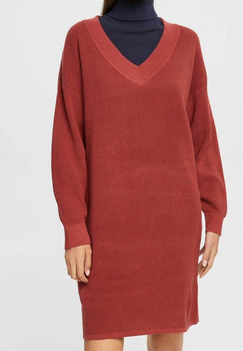 Abito lavorato a maglia color ruggine con maniche lunghe e scollatura a V ampia, caratterizzato da un tessuto testurizzato e una vestibilità rilassata.