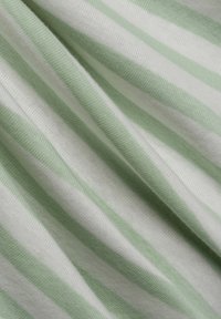 Green and white striped fabric, featuring a soft, textured knit with alternating bold and subtle stripes, draping smoothly.