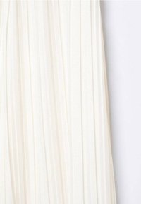 Robe plissée en tissu blanc cassé, présentant des plis verticaux et une texture lisse. Le design est simple, sans matériel ou accents visibles.