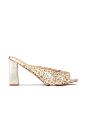 Guld slingback højhælede sandaler med vævet, åben tå-design og blokhæle på en hvid baggrund.