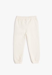 Lichtgekleurde sweatpants van zacht katoen. Voorzien van een elastische tailleband en taps toelopende boorden. Geen zakken of zichtbare patronen.