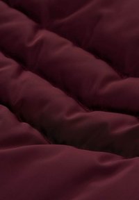 Bordeaux gekleed stof met zichtbare gestikte naden, een gladde textuur en een subtiele glans, die een zachte, lichte ontwerpen laat zien.