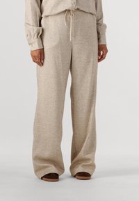 Beige visgraat wijde broek met een trekkoord in de taille en textuurstof. Bevat opgerolde boorden met knoopaccenten en open teen schoenen.