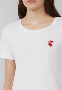 Witte kortaf mouwen t-shirt met een ronde halslijn en een rood geborduurd kersenontwerp met het woord "happy." Zachte katoen, gladde textuur.