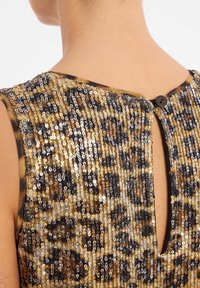 Robe à paillettes avec un motif léopard dans des tons d'or, de noir et de bronze ; fermeture à boutons au dos avec une petite découpe en forme de trou de serrure.