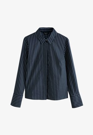 Chemise bleu marine à manches longues avec rayures verticales blanches, col et fermeture boutonnée à l'avant. Présente une coupe ajustée et des manches retroussées.