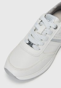 Hvite lær sneakers med jevn overflate, sølvfargede detaljer, perforerte elementer og teksturert hvit snøring med plastsnørefeste.