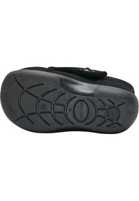 Svart toffelbas med en texturerad gummisula med upphöjda greppmönster och en fluffig ovansida. Kardborreband för säker passform.