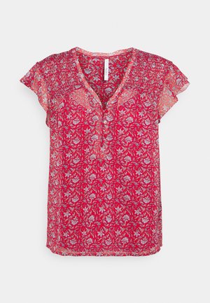 Blouse florale rouge avec des manches courtes à volants, décolleté en V et détail de boutons. Présente des motifs floraux complexes en blanc et bleu sur un tissu transparent.