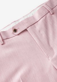 Pantalones rosas con una textura suave, que cuentan con un cierre de botón y una cinturilla ajustada. La tela es ligera y tiene un sutil patrón jaspeado.