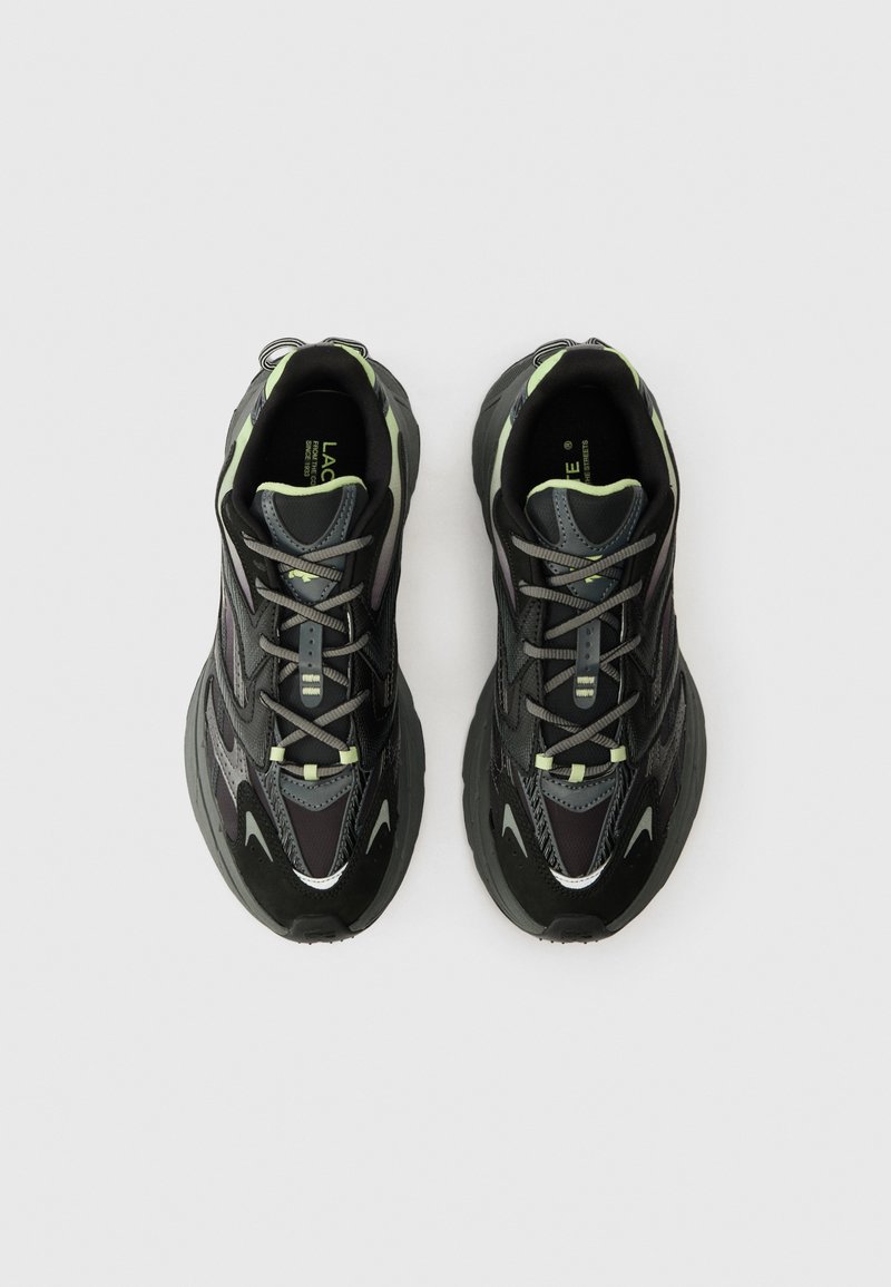 Pair of black and gray sports sneakers with light green accents, viewed from above on a white background.