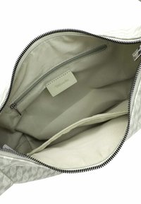 Borsa con cerniera in tessuto grigio chiaro con motivo geometrico. L'interno presenta due tasche aperte e una tasca con cerniera. Texture morbida, design minimalista.