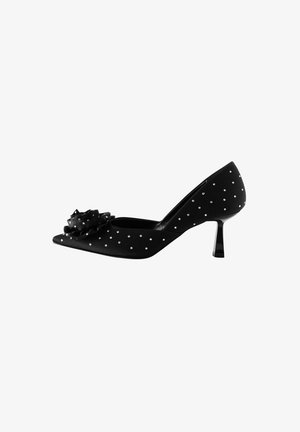 Scarpa con tacco alto in satin nero caratterizzata da punta affusolata, decorazioni floreali e motivo a pois bianchi. Struttura del tacco sottile e lucida.