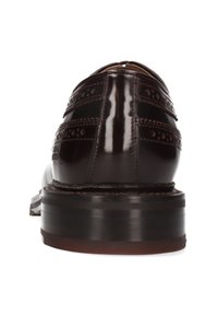Scarpa di pelle marrone lucida con dettagli brogue, punta arrotondata e tacco impilato, caratterizzata da una finitura liscia e lucida.