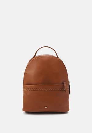 Sac à dos en cuir marron avec une forme arrondie, doté d'une poignée supérieure et d'un accent cousu à l'avant. Fermeture éclair.