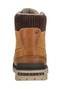 Ruskeat nahkakengät, joissa on ribattu ruskea tekstiilikaulus ja kerma-valkoinen tikkaus. Varustettu mustalla kumipohjalla ja pyöreällä logo-yksityiskohdalla.