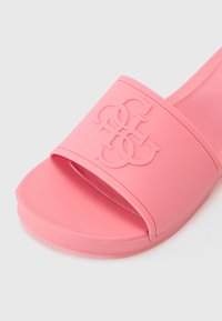 Rosa sklidesandal med bred stropp med preget logo, avrundet fotseng og glatt gummitekstur. Enkelt og lett design.