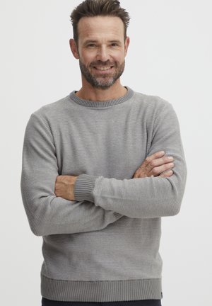 Pulover tricotat de culoare gri deschis, cu guler rotund ribbat, mâneci lungi și un model texturat. Prezintă un tiv și manșete ribbate în contrast.