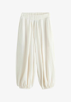 Løse hvide teksturerede bukser med elastisk taljebånd og elastiske manchetter ved anklerne, designet til en afslappet og komfortabel pasform.