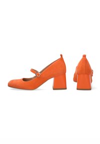 Oranžové semišové balerínky Mary Jane s kulatou špičkou, nastavitelným páskem a výrazným, blokovým podpatkem. Hladká textura a jednoduchý design.