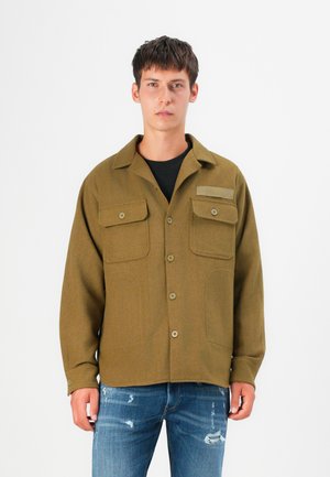 Olive green jacket made of textured fabric, featuring a button closure, two front pockets, and a brand label on the chest.